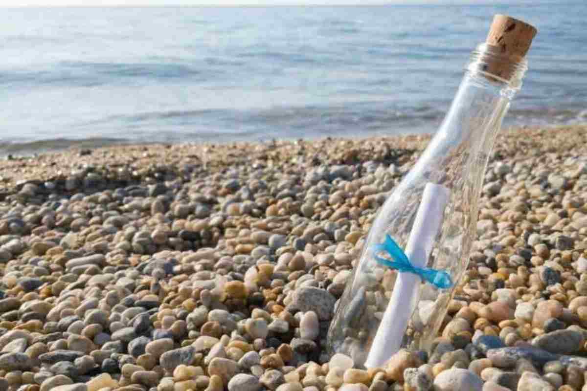 una bottiglia in riva al mare con dentro un biglietto