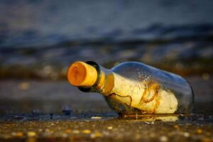 bottiglia in riva al mare con un messaggio dentro