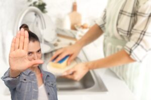 donna che lava i piatti a mano e un'altra che fa stop con le mani