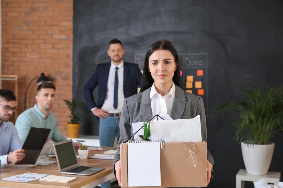 dipendete licenziata dal suo posto di lavoro con tra le mani uno scatolone per trasportare le sue cose