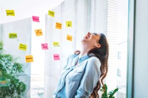 una persona che parla ad alta voce e tanti bigliettini vicino