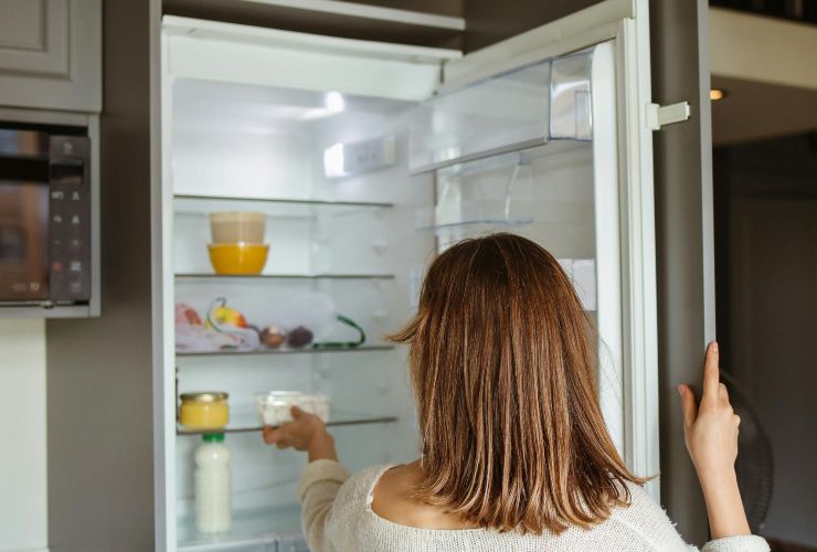 Donna che prende qualcosa dal frigorifero